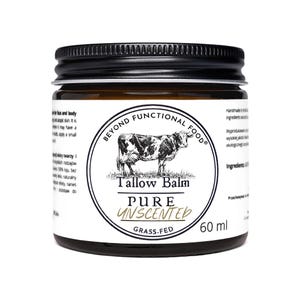 May include: A 60 ml amber glass jar with a black screw-top lid, featuring a white label with a black cow illustration. The text reads Beyond Functional Food, Tallow Balm, Pure Unscented, and Grass-Fed, with additional small text on the sides.