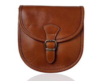 May include: A brown leather crossbody bag with a flap closure and a buckle. The bag has a rounded shape and a stitched design.
