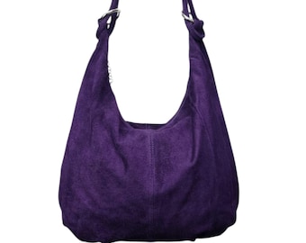 May include: A deep purple suede hobo bag with a single shoulder strap. The bag has a rounded shape and a soft, textured appearance. Silver-toned metal rings attach the strap to the bag.