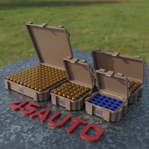 May include: Several tan plastic cases, some open, filled with brass-colored bullets. One case has a blue insert. The number "45" is printed on the cases. The red text "45 AUTO" is in the foreground.