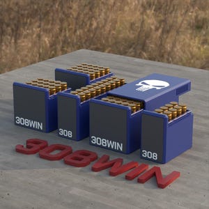 May include: A display of blue and black ammunition boxes, each filled with brass-colored bullets. The boxes are labeled "308WIN" and "308". One box features a white skull graphic. Red 3D text spells out "308WIN" on the surface.