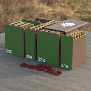 Peut inclure: Un ensemble de quatre boîtes de rangement de munitions vertes et brunes remplies de cartouches en laiton. Chaque boîte est marquée du nombre 338 en blanc. Une boîte porte un logo de crâne blanc. Des lettres rouges forment SNIPE-TAC.