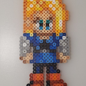 May include: A pixel art character made of colorful beads. The character has blonde hair, a blue shirt, and brown boots.
