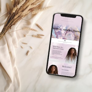 May include: A mobile phone displaying a website for a spiritual growth journey. The website features a pink and purple background with a woman's face and the text "Spiritual | Growth | Journey".