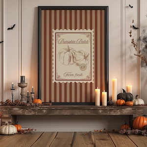 Puede incluir: Una impresión enmarcada con una ilustración de calabaza y el texto "Pumpkin Patch" se exhibe en una estantería de madera. La estantería está decorada con velas, calabazas y follaje otoñal, creando un tema de temporada.
