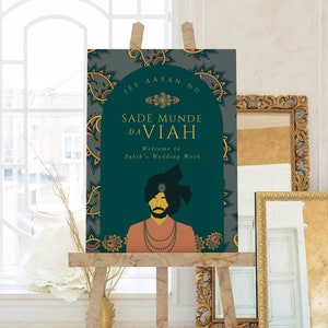 May include: A teal and gold wedding sign with the text "Sade Munde Da Viah" and "Welcome to Sahib's Wedding Week". The sign features a traditional illustration of a man wearing a turban and a gold necklace.