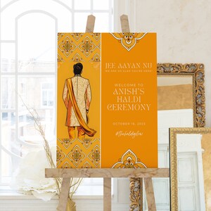 May include: An orange sign on a wooden easel, announcing "Anish's Haldi Ceremony" for October 16, 2023. The sign includes an illustration of a person in traditional clothing and decorative patterns.
