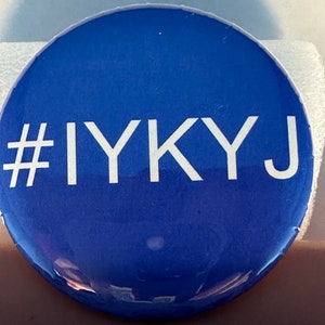 Puede incluir: Un botón redondo azul con texto blanco que dice "#IYKYJ".