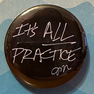 Peut inclure: Bouton noir avec du texte blanc qui dit "It's All Practice" avec un petit "am" écrit en dessous du texte.