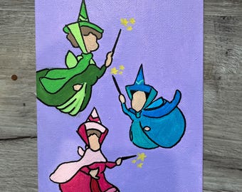 Könnte beinhalten: Handgemalte Leinwand mit drei Cartoon-Feen in grünen, blauen und rosa Kleidern, die jeweils einen Zauberstab mit gelben Sternen halten. Der Hintergrund ist einfarbig lavendelfarben.