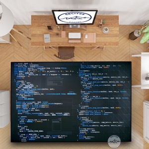 May include: A top-down view of a home office desk with a computer monitor displaying code on a dark blue background. The code is written in a light blue font and includes the words "error", "matrix", "buffer", and "data". The desk is made of wood and has a variety of items on it, including a mouse, a cup of coffee, and a plant. The desk is in front of a white wall.
