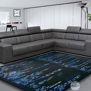 May include: A dark gray sectional sofa with a black and blue rug featuring code on it. The rug has a dark background with blue code on it.