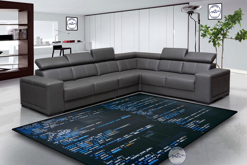 May include: A dark gray sectional sofa with a black and blue rug featuring code on it. The rug has a dark background with blue code on it.