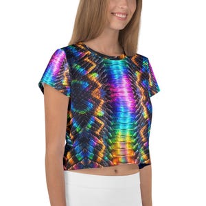 Puede incluir: Un top corto de manga corta con un vibrante estampado de piel de serpiente multicolor. El diseño presenta un espectro de colores, incluyendo azul, morado, naranja y amarillo, creando un efecto brillante. El top es de estilo ajustado.
