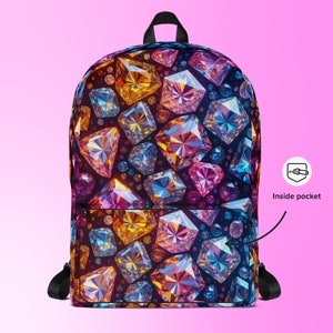 May include: A backpack with a vibrant pattern of colorful, gem-like shapes in shades of yellow, orange, pink, blue, and purple. The backpack has black straps and a top handle. The words "Inside pocket" are visible.