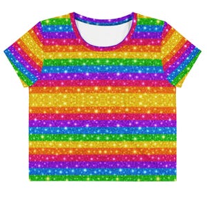 May include: A short-sleeved crop top featuring a vibrant horizontal rainbow stripe pattern. The design displays a glittery, sparkling texture in shades of red, orange, yellow, green, blue, and purple, with a solid white inner collar lining.
