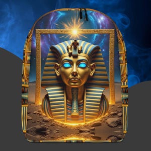 Könnte beinhalten: Ein Rucksack mit einer detaillierten Illustration einer Pharaonenbüste mit blauen Augen, verziert in Gold und Blau. Das Design umfasst Hieroglyphen und einen kosmischen Hintergrund, der ein altägyptisches Thema hervorruft.