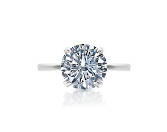 May include: A silver ring with a large, round, clear diamond.