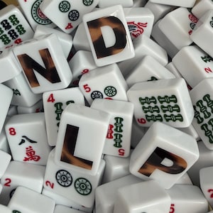 May include: A collection of white rectangular Mahjong tiles featuring various green and red symbols, numbers, and characters. Three prominent tiles are printed with the large black letters N, D, and L, each featuring a brown leopard print pattern.