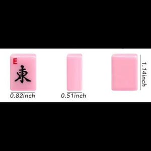 May include: Three pink Mahjong tiles are displayed, showcasing the "East" wind symbol. Measurements are provided: 0.82 inches wide, 1.14 inches tall, and 0.51 inches thick. The tiles are set against a black background.