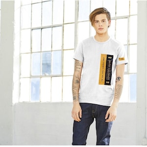 May include: A white t-shirt with a black and yellow label on the front. The label reads "FOR 8mm - ROLL CAMERAS ONLY - EASTMAN KODAK COMPANY".