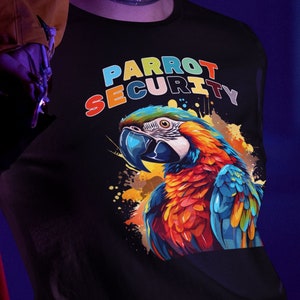 May include: Black long-sleeve shirt with the text "PARROT SECURITY" in colorful letters above a vibrant illustration of a macaw. The macaw features blue, red, and yellow feathers.
