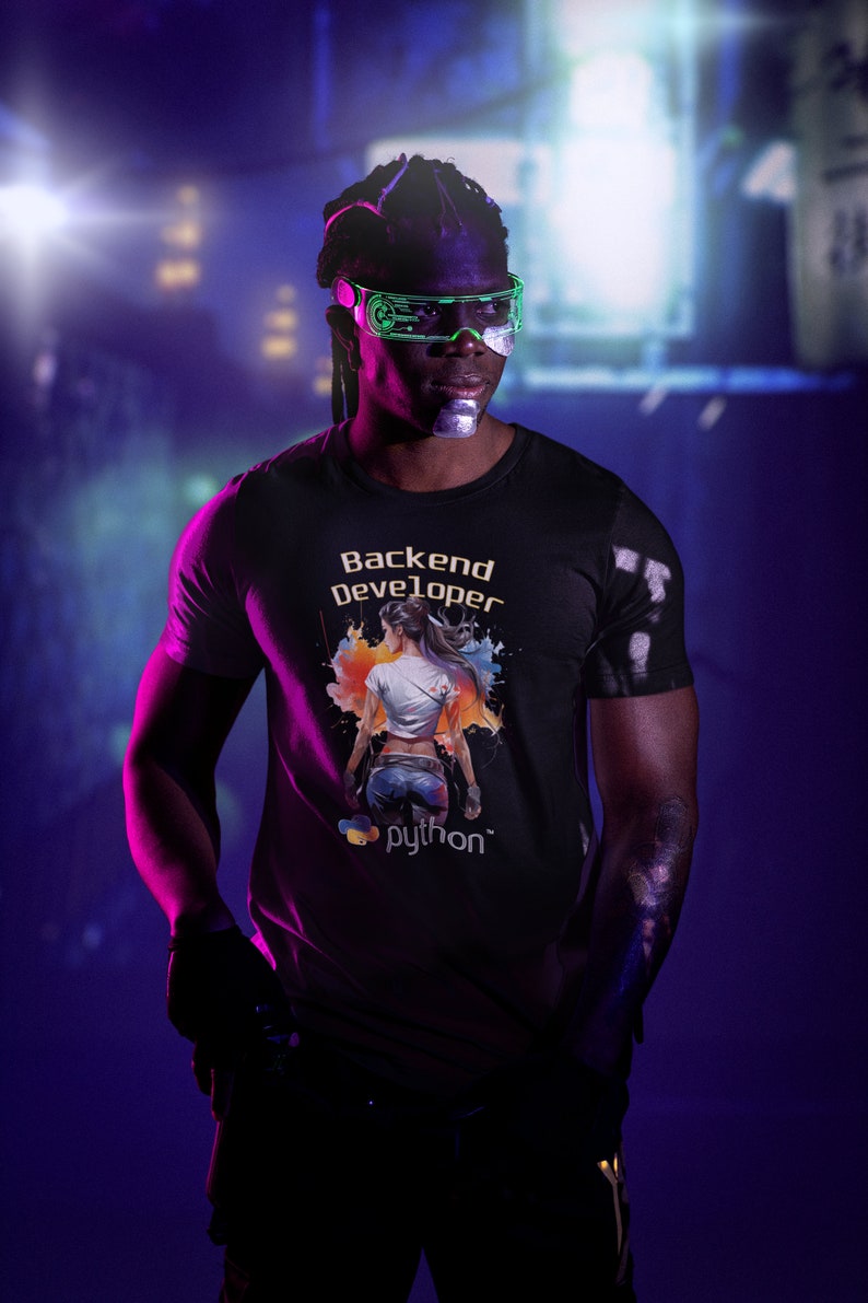 K&ouml;nnte beinhalten: Eine Person tr&auml;gt ein schwarzes T-Shirt mit einer bunten Grafik einer Frau und dem Text "Backend Developer" und "python". Die Person tr&auml;gt eine gr&uuml;ne und schwarze Brille.