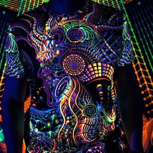 Puede incluir: Una camiseta negra con un diseño psicodélico colorido que presenta formas geométricas, espirales y una figura similar a una criatura. El diseño brilla intensamente bajo la luz negra.