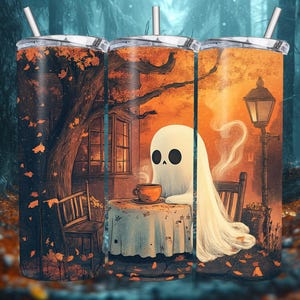 May include: Three stainless steel tumblers with a Halloween theme. The tumblers feature a ghost sitting at a table with a cup of coffee, a tree with orange and yellow leaves, and a street lamp. The background is a dark forest.