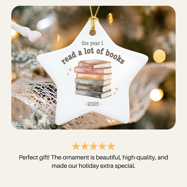 May include: White star-shaped Christmas ornament with gold string. The ornament features a stack of books and the text "the year I read a lot of books - 2025-". The ornament is a holiday decoration.