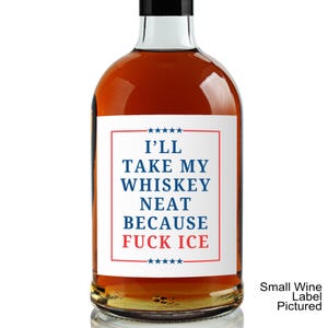 Puede incluir: Una botella de vidrio llena de l&iacute;quido &aacute;mbar con una etiqueta rectangular blanca con borde rojo y estrellas azules. El texto dice I'LL TAKE MY WHISKEY NEAT BECAUSE FUCK ICE en letras azules y rojas. La botella tiene una tapa negra.