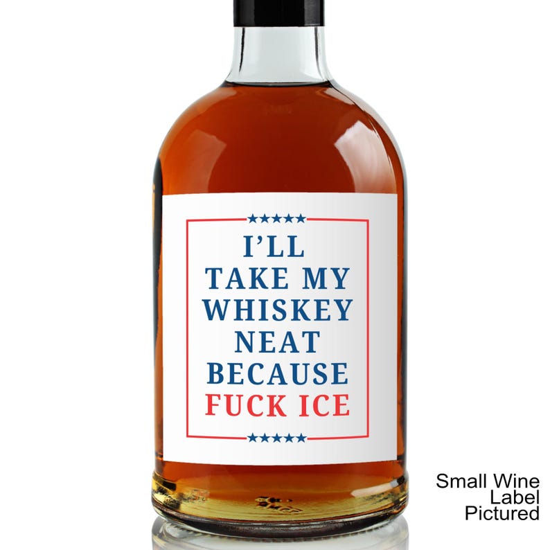 Puede incluir: Una botella de vidrio llena de l&iacute;quido &aacute;mbar con una etiqueta rectangular blanca con borde rojo y estrellas azules. El texto dice I'LL TAKE MY WHISKEY NEAT BECAUSE FUCK ICE en letras azules y rojas. La botella tiene una tapa negra.