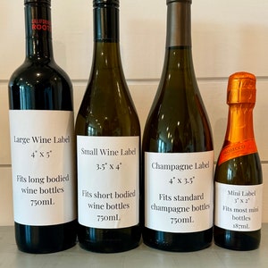 Four wine bottles with labels showing different sizes and dimensions. The labels read 'Large Wine Label 4' x 5' Fits long bodied wine bottles 750mL', 'Small Wine Label 3.5' x 4' Fits short bodied wine bottles 750mL', 'Champagne Label 4' x 3.5' Fits standard champagne bottles 750mL', and 'Mini Label 3' x 2' Fits most mini bottles 187mL’.