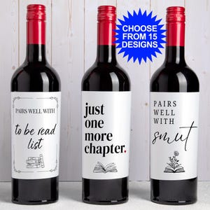 May include: Three dark glass wine bottles with red foil caps and white labels. The labels feature black text reading "PAIRS WELL WITH to be read list", "just one more chapter.", and "PAIRS WELL WITH smut", along with book illustrations and a blue starburst graphic.