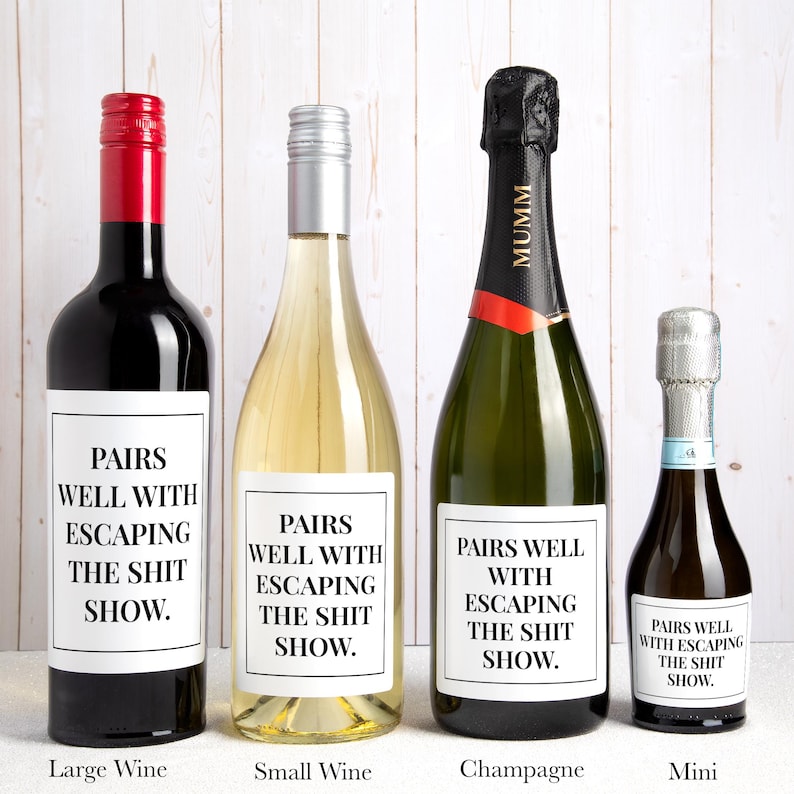 May include: Four bottles of varying sizes, including a large wine bottle with a red cap, a small wine bottle with a silver cap, a champagne bottle with a black foil top, and a mini bottle, each featuring a white label with the text PAIRS WELL WITH ESCAPING THE SHIT SHOW.