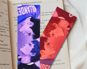 May include: Two illustrated bookmarks featuring portraits of young men. One bookmark has a blue and purple gradient, the other a red gradient. The bookmarks are placed on an open book with text from "Around the World in Eighty Days."