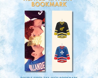 May include: Double-sided 2x6 inch bookmark featuring two hockey jerseys and a romantic illustration. One side displays a black and gold jersey with a cannon graphic. The other side shows a blue and red jersey with a fleur-de-lis.