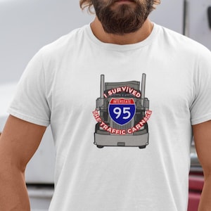 May include: White t-shirt with a graphic of a semi-truck with the text "I Survived the I-95 Traffic Carnage".