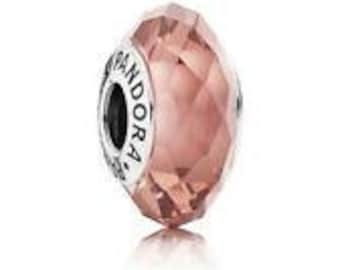 May include: A faceted glass bead charm in a light pink color with a silver metal core and the word "Pandora" engraved on the side.