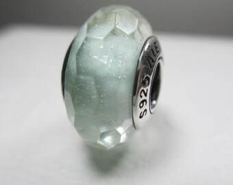 May include: A light blue glass bead with a silver metal charm. The charm has the text "S925 ALE" engraved on it.
