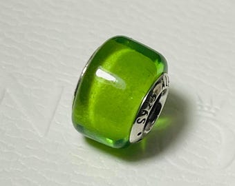 May include: A green glass bead charm with a silver metal band. The band is engraved with the text "S925 ALE".