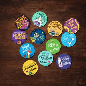 May include: A collection of colorful round coasters with various cartoon character designs and quotes. The coasters feature phrases like "Best Day Ever!", "Boat Snack!", and "Who's your favorite Possum?" on a dark wood surface.