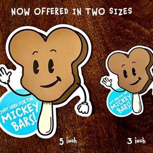 May include: Two brown and white Mickey Bar stickers with a cartoon face and arms. The larger sticker is 5 inches and the smaller sticker is 3 inches. Both stickers have a blue circle with the text "Just here for the Mickey Bars!"