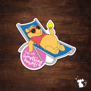 May include: A sticker featuring Winnie the Pooh relaxing on a blue and white beach chair, wearing sunglasses and holding a yellow ice cream cone. The sticker has the text "Time for Something Sweet!" in a pink circle.