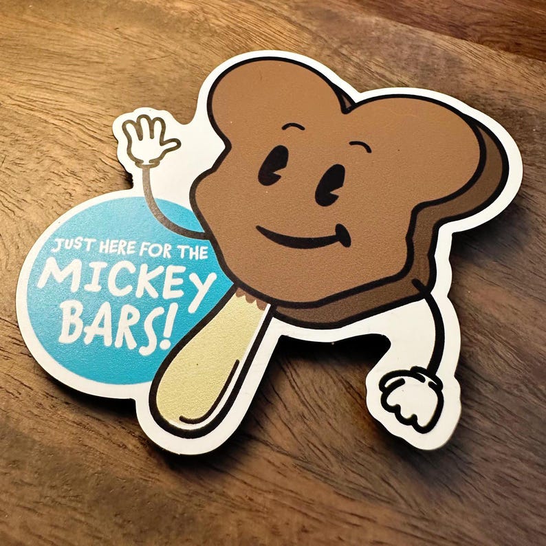 May include: A brown Mickey Mouse shaped ice cream bar with a stick and a blue circle with the text "Just here for the Mickey Bars!"