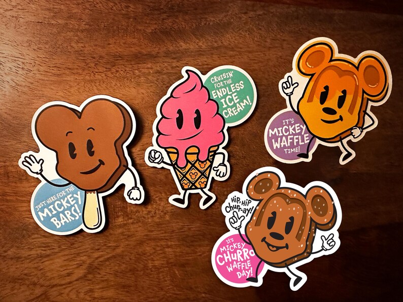 May include: Four colorful stickers featuring Mickey Mouse-themed ice cream treats. The stickers feature Mickey Mouse's head with different ice cream flavors, including a chocolate bar, a waffle cone, a churro, and a waffle. Each sticker has a fun slogan related to the ice cream treat.