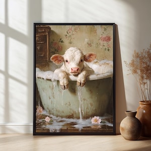 May include: Framed art print featuring a white calf relaxing in a vintage green bathtub filled with bubbles. The calf is the focal point, with its pink nose and ears visible. The background includes floral wallpaper and a wooden floor.