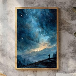 Op de afbeelding: Een ingelijste kunstdruk met een aquarel schilderij van een sterrenhemel. Het kunstwerk toont een silhouet op een heuvel, met uitzicht op een landschap van bergen en bomen. Het kleurenpalet omvat tinten blauw, goud en bruin.