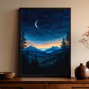 May include: A framed landscape painting depicts a nighttime mountain scene. The artwork features a dark blue sky filled with stars and a crescent moon. Below, layers of blue mountains and a dense forest are visible.