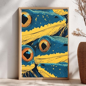May include: A framed art print featuring a close-up of three stylized frog faces. The frogs have blue skin with yellow accents and large orange eyes. The artwork is in a pop art style.